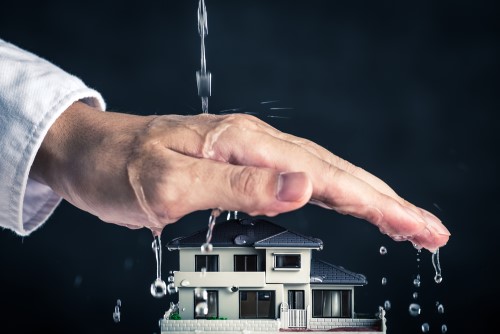 depiction of insurance agents hand sheltering home from flood